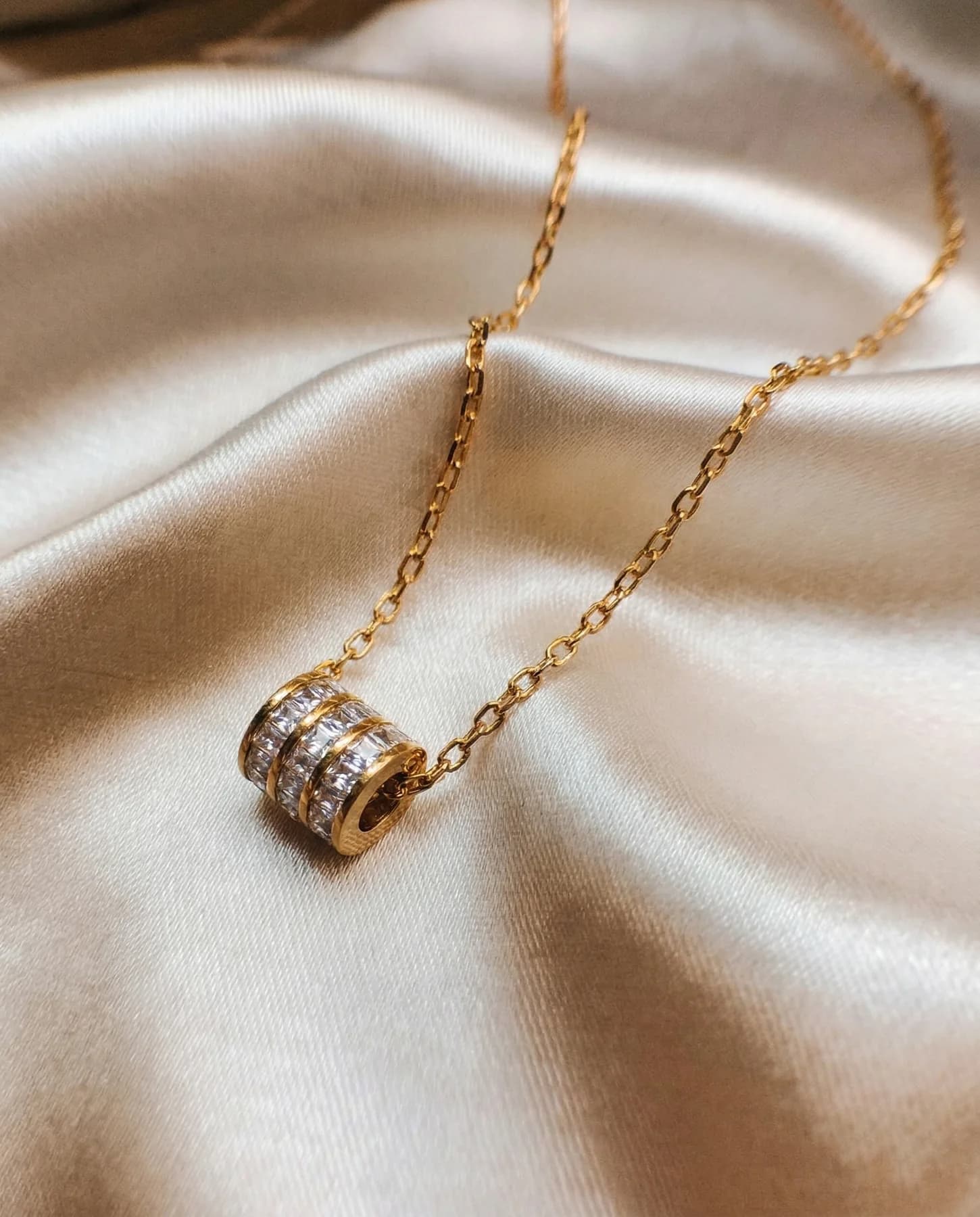 Gold crystal pendant on satin